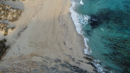 A beautiful aerial view showcasing a serene coastal beach with its clear, inviting waters