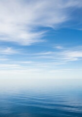 Obraz premium Calm Blue Seascape with Clear Sky and Soft Clouds.
