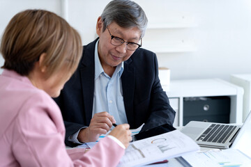Asian business professionals review financial reports collaborate strategy modern office setting effective decision making