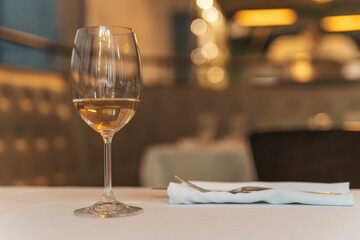 Glass of White Wine on Restaurant Table. Elegant Dining Atmosphere