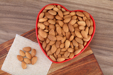 Fresh almonds in heart shaped bowl