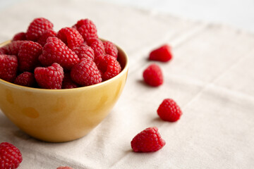 Organic Raw Red Raspberries in a Bowl, side view. Copy space.