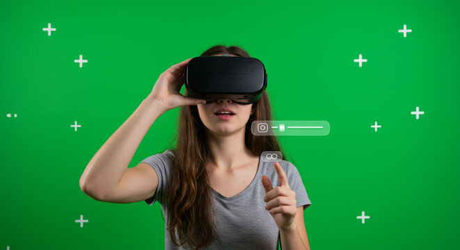 Woman wearing VR headset interacts with futuristic interface, exploring immersive digital worlds on green screen