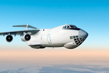 White wide body transport freight airliner fly in the air above the clouds