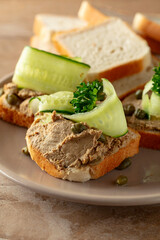 Open sandwiches with pate, cucumber, capers, and parsley.