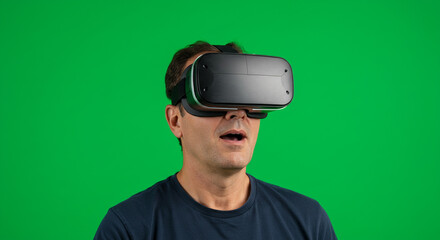 Man reacts with awe and surprise wearing virtual reality headset against vibrant green screen background