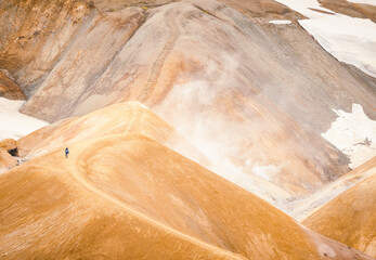 Icelandic highland landscape at Kerlingarfjöll mountains with orange soil, hot springs and snow