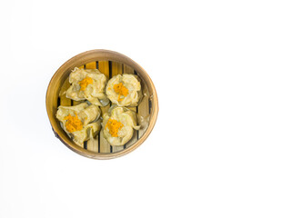 Traditional steamed dim sum dumplings in a bamboo basket isolated on a white background. Asian cuisine, Chinese food concept.