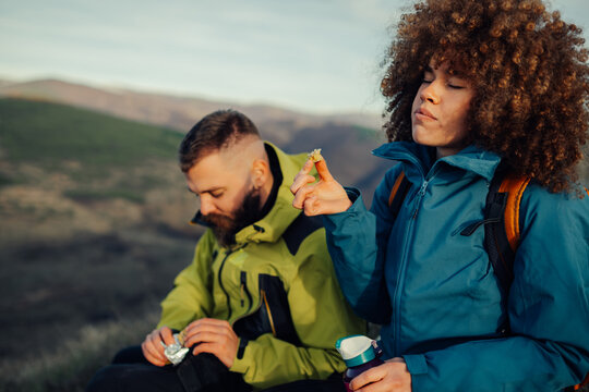 Hikers resting and eating snacks on mountain top