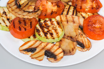 Grilled sliced button mushroom and different vegetables on plate, fragment