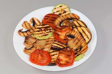 Grilled sliced big button mushroom and different vegetables on plate