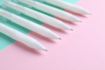 White pens on color background, closeup view