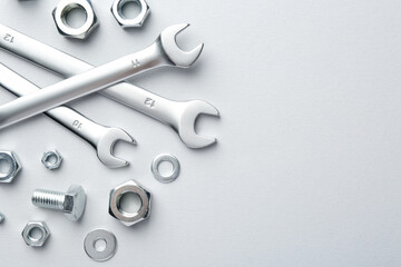 Metal wrenches, nuts and bolt on white background, flat lay. Space for text
