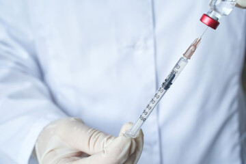 close up of gloved hands holding a syringe with precise measurement for medical injection purpose.