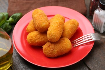 Delicious fried croquettes served on wooden table, closeup