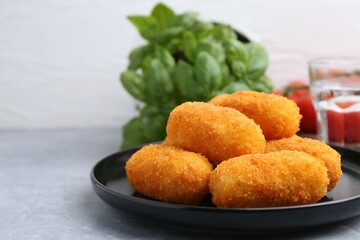 Delicious fried croquettes on gray table, closeup