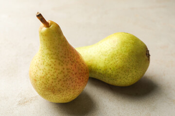 Fresh ripe pears on light grey table, closeup