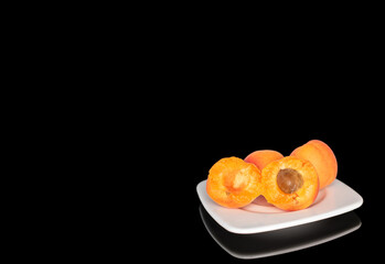Ripe organic apricots isolated on black background, macro.