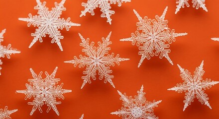 Sparkling snowflake decorations scattered on a vibrant orange background for a festive holiday scene