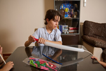 Boy Inflating Long Balloon with Pump at a Home Environment