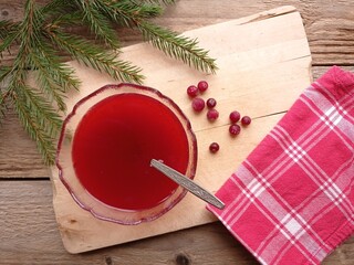Top view of a small glass bowl full finnish dessert soup made from cranberries on a wooden cutting...