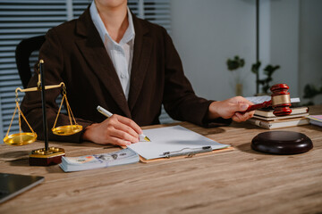 Law office with legal books and scales on table. Legal consultation: lawyer and client reviewing...