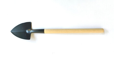 Small garden shovel with wooden handle and black metal blade on white background, top view.