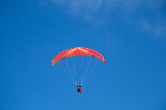 Persone su paracadute rosso per parapendio
