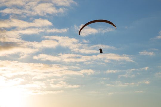 Persone su paracadute per parapendio in cielo con nuvole
