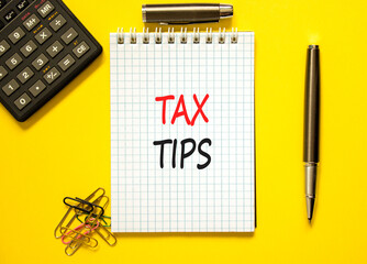 Tax tips symbol. Concept word Tax tips on beautiful white note. Black calculator. Black pen....