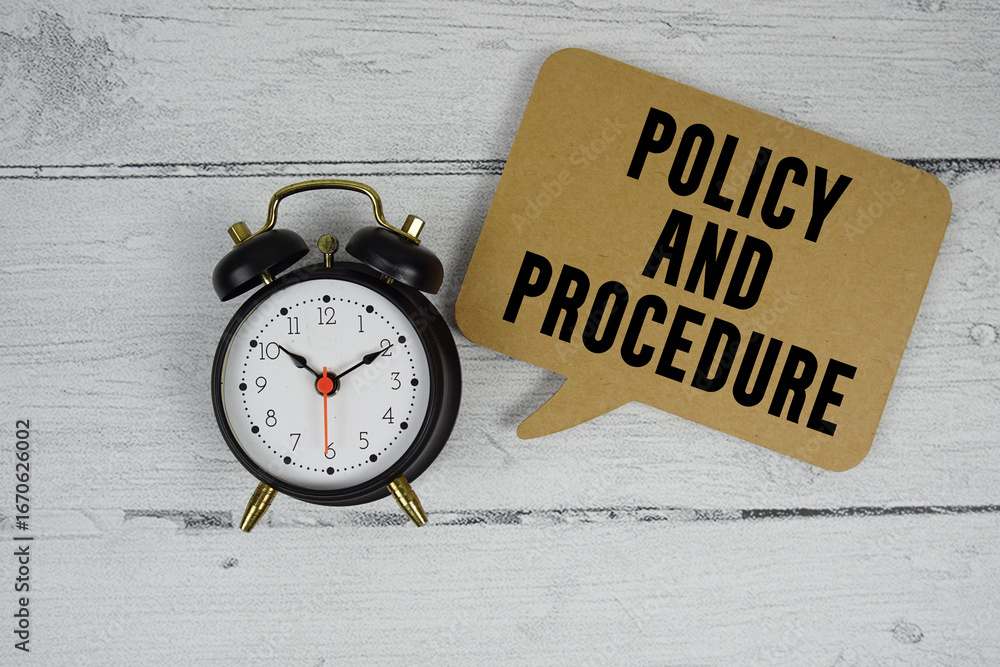 Poster policy and procedure text with alarm clock on wooden background
