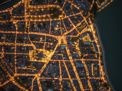 Drone aerial night view of illuminated city streets in Hoorn