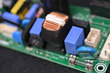 Close-up of brass parts of a coil on a printed circuit board.
