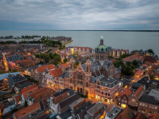 Drone aerial evening view of basilica and rooftops in Hoorn