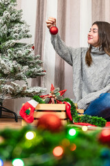 Girl looking at Christmas bauble with excitement and blurred lights