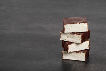 Vanilla souffle in chocolate glaze. Dark background. Copy space