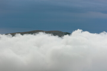 A layer of clouds between two high mountain plateaus. View of the Demerdzhi plateau in Crimea.