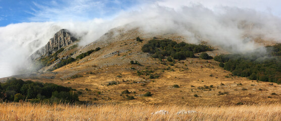 Mysterious rocky cliffs shrouded in clouds or fog. The Chatyr-Dag mountain range in Crimea.