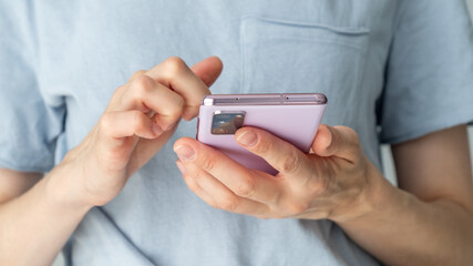 A person is holding a pink cell phone in their hand