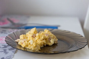Scrambled eggs with salami in a large frying pan