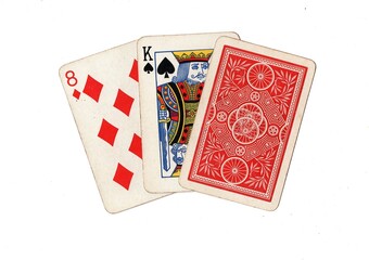 A hand of three vintage playing cards with two cards revealed on a white background.