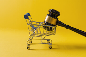 Gavel in Shopping Cart on Yellow Background