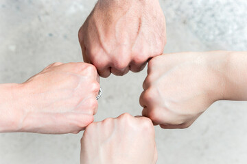 Group of hands joining in strength. A group of four fists joined together in a gesture of teamwork, strength, and unity. Partnership, success, support, community, cooperation, group, power, people