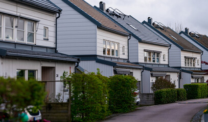 Modern townhouses with uniform roof design at dusk.