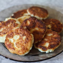 A plate of golden-brown curd cheesecakes stacked neatly