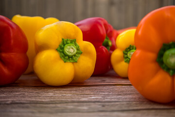 Yellow and red bell peppers close-up on wooden surface