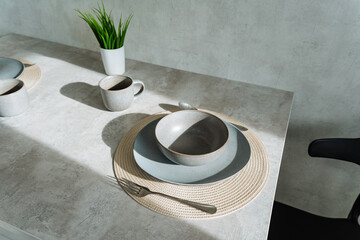 A minimalist dining table with vibrant greenery and warm natural sunlight creates an inviting atmosphere ideal for entertaining guests and enhancing the dining experience