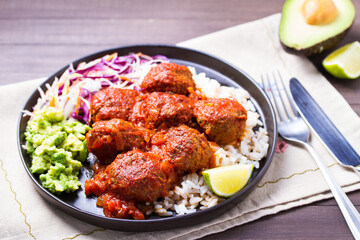 Beef meatballs in tomato sauce with rice, mashed avocado and coleslaw