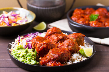 Beef meatballs in tomato sauce with rice, mashed avocado and coleslaw