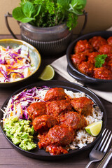 Beef meatballs in tomato sauce with rice, mashed avocado and coleslaw